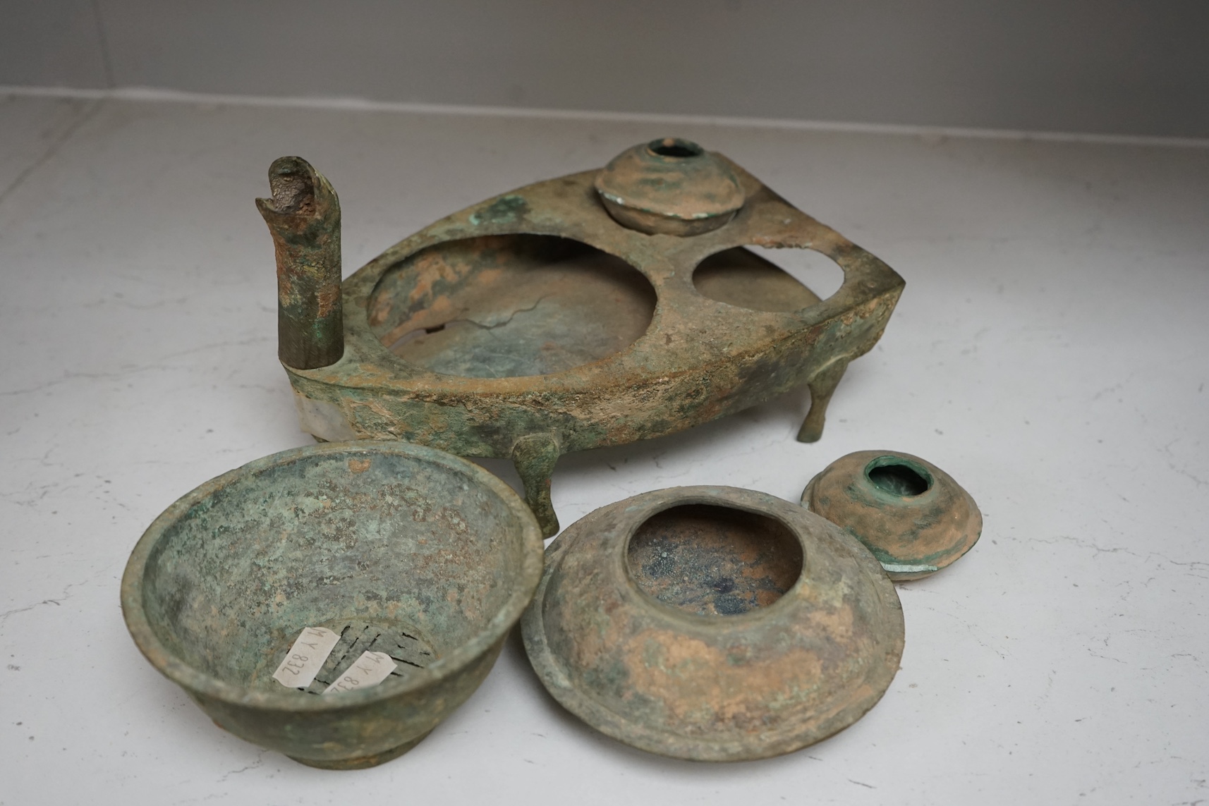 Four Chinese bronze zoomorphic stoves, Han Dynasty, 22cm, together with a Han Dynasty bronze brazier and vessels, width 22.5cm, (5). Condition - poor to fair.